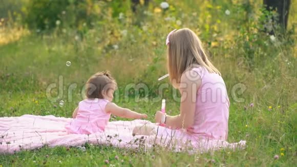 妈妈和女儿正坐在草坪上视频的预览图