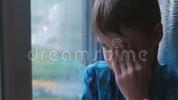 男孩在雨中看着窗外很伤心视频的预览图