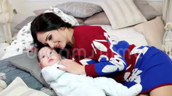 母亲和婴儿的肖像一个年轻的女人抚摸拥抱抚摸他的小儿子一个舒适的家视频的预览图