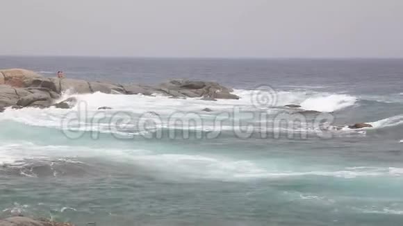 暴风雨中海浪撞击巨石浪花飞溅四面八方视频的预览图