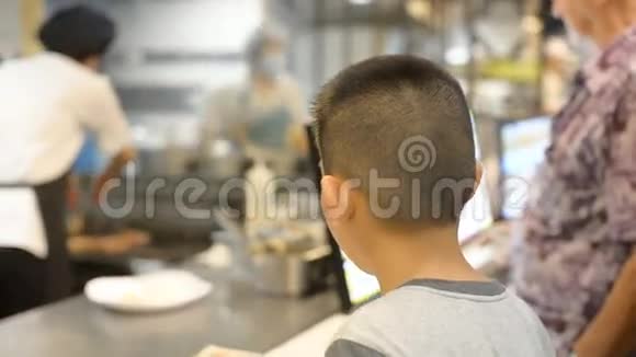 亚洲男孩在食物场等待他的食物生活方式的概念视频的预览图