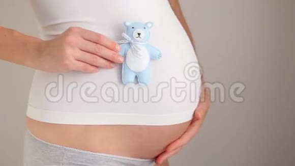 怀孕女孩抱着小熊玩具蓝色视频的预览图