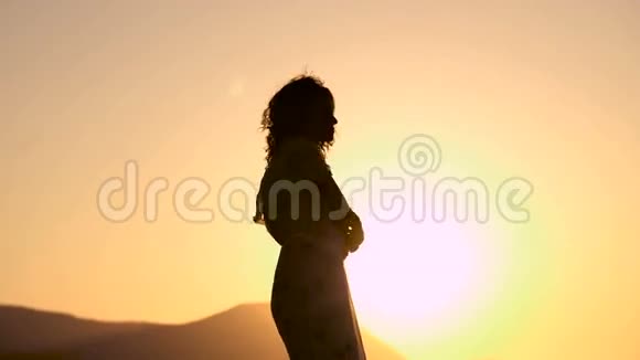 美丽的年轻女子穿着裙子在夕阳下跳舞视频的预览图