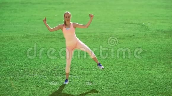 苗条的运动女人在绿草上做运动视频的预览图