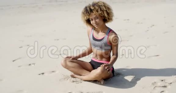 在沙滩上穿运动服装的女人视频的预览图