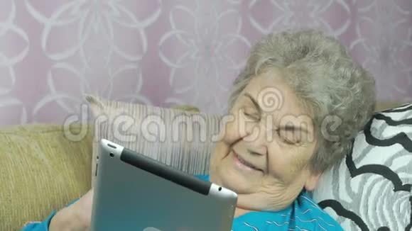 微笑的高级妇女躺在酒店的沙发上视频的预览图