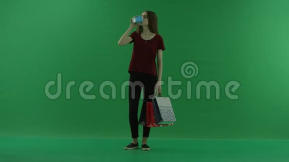 漂亮的购物女人拿着购物袋四处张望喝着一杯咖啡或茶持有女购物者视频的预览图
