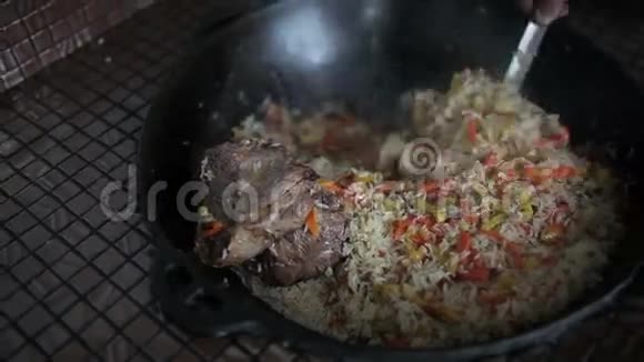 米饭配蔬菜和羊肉搅拌水壶视频的预览图