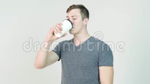 年轻人喝白色背景的一次性纸杯咖啡视频的预览图