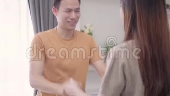 亚洲夫妇在家里的客厅里边听音乐边跳舞视频的预览图