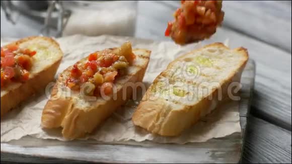 勺子把蔬菜放在面包上视频的预览图