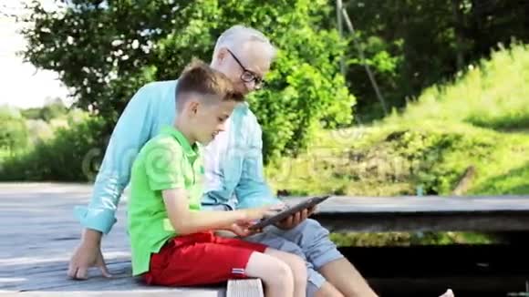 祖父和男孩带着平板电脑在河泊32号视频的预览图