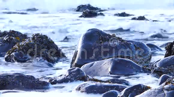 黑色圆形石头在塔利斯克湾西海岸的斯凯岛在晚上涨潮巨大的海浪视频的预览图