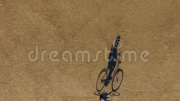 自行车和骑手的影子在公园里慢慢移动从顶部看不寻常的景色视频的预览图
