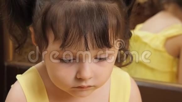 孩子的情绪一个大眼睛的小女孩在哭一个穿着黄色裙子的孩子在镜子旁视频的预览图