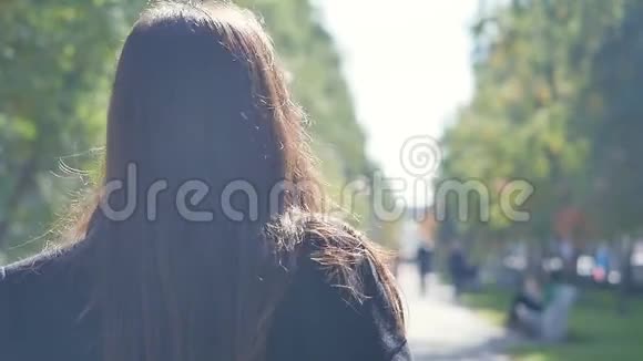 一个美丽快乐外表迷人的年轻女孩正拿着一杯咖啡走在城市的街道上视频的预览图