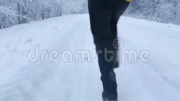 女孩在冬天的森林里在路上奔跑从下面的双脚特写视频的预览图