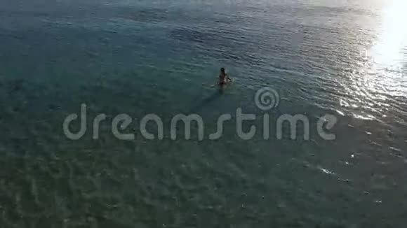 漂亮的年轻女人把水溅到海里视频的预览图