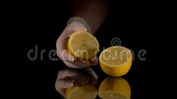 在黑暗的背景上用手捏柠檬视频的预览图