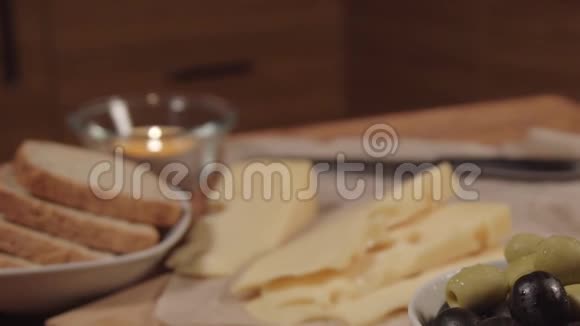 木桌上放着橄榄的艾莫塔尔奶酪视频的预览图