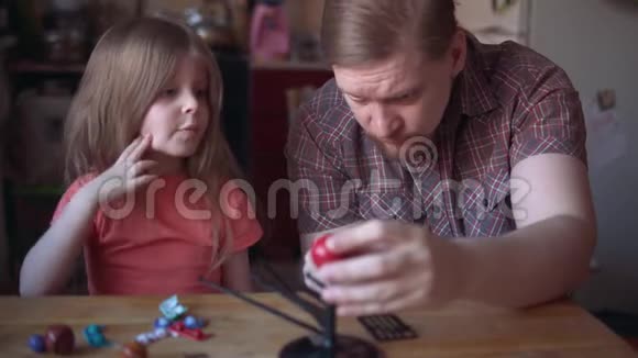 爸爸和可爱的孩子在房间里做太阳系的模型视频的预览图