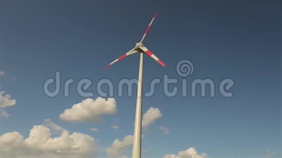 风力发电机背景下的云浮在天空大型风力发电机叶片的旋转视频的预览图