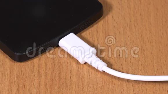女性手拔下白色微型USB电缆至智能手机视频的预览图