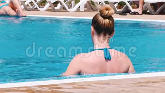 性感的年轻女子在游泳池里放松视频的预览图