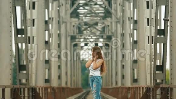 一位留着长发的少女站在铁路上等着别人视频的预览图