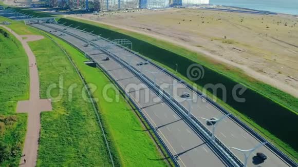 以现代城市为背景的城市建筑在高速公路上行驶的汽车视频的预览图