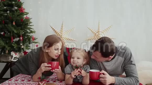圣诞节早上这个年轻的家庭幸福地互相玩耍在床上放很多枕头圣诞礼物视频的预览图