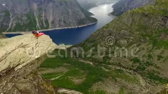 挪威坐在巨人边缘的男人和女孩视频的预览图