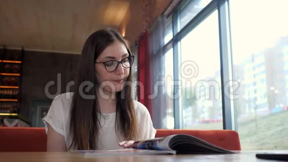 在咖啡馆吃饭的女孩在咖啡馆看菜单视频的预览图