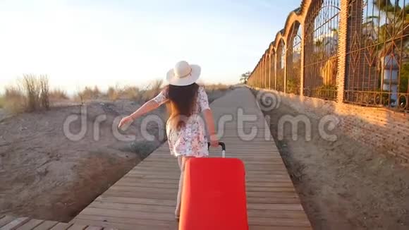 年轻的女人带着红色的手提箱跑视频的预览图