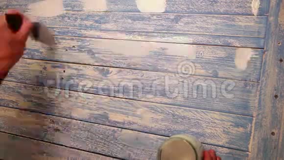 一名男子用白色油漆在木板上作画的加速镜头视频的预览图