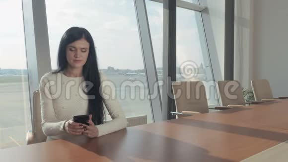 漂亮的黑发女人在机场打电话视频的预览图