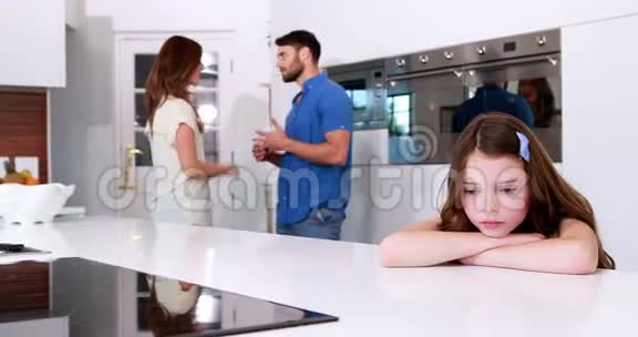 伤心的女孩低头看着父母争吵视频的预览图