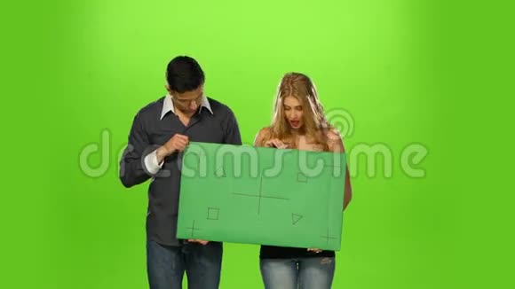 一对夫妇举着一个空白的牌子绿色的屏幕视频的预览图