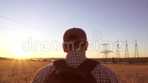 一个旅行者走在麦田朝太阳走去视频的预览图