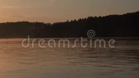 一个人骑着划艇在湖上黄昏的时候湖上金色夕阳日出休闲性质概念视频的预览图