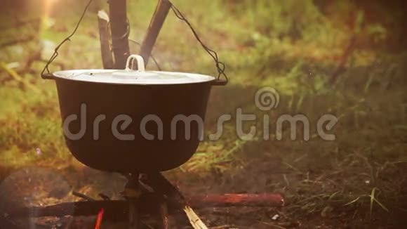 露营场景篝火上挂着一个装满食物的锅视频的预览图