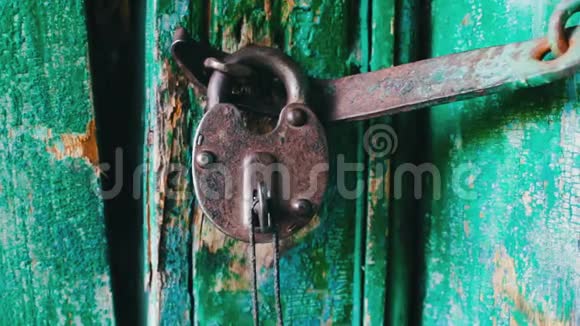 旧的老式铁锁在门上绿色油漆剥落把钥匙插在里面闭着眼睛视频的预览图