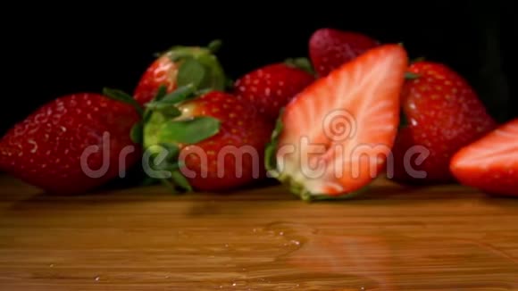 成熟的草莓落在潮湿的木板上视频的预览图