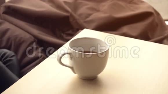 女孩拿起一杯茶在桌上喝然后放视频的预览图