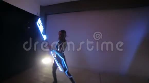 Led显示一男一女在一个有背光的小舞台上手中握着扭曲的LED风扇视频的预览图