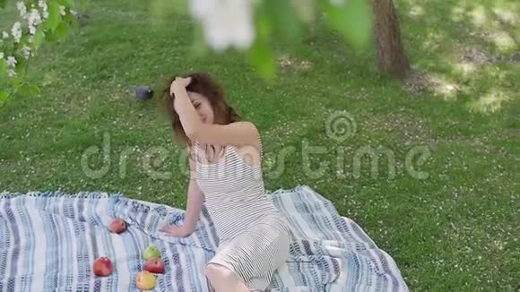 年轻女子在树前享受躺在地毯上视频的预览图