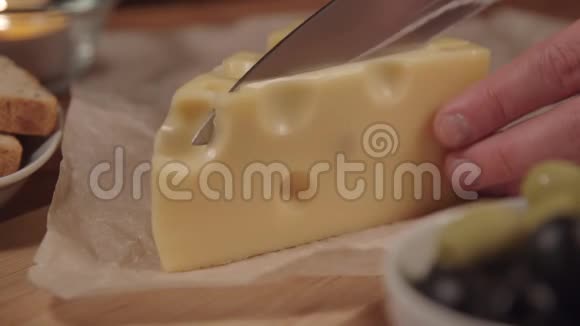 女人在木制烹饪板上切奶酪女人切奶酪视频的预览图