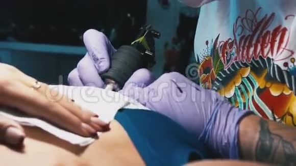 纹身师在女人的身体特写做纹身视频的预览图