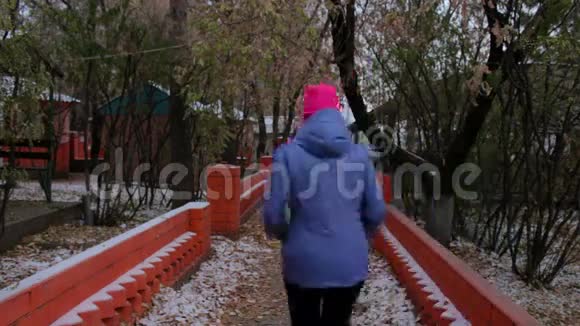 寒冷的阴天女孩在秋天的公园里跑步在户外运动的妇女视频的预览图