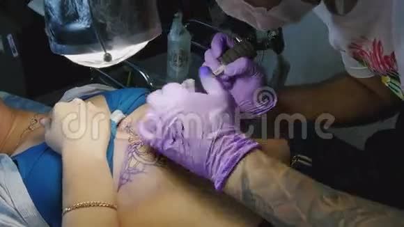 纹身师傅在女人身上做纹身视频的预览图